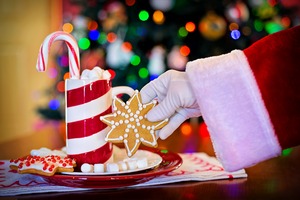  Santa eating a cookie with milk in a home